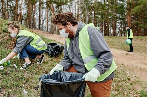 Grupo de voluntários coletando lixo na floresta Foto Premium