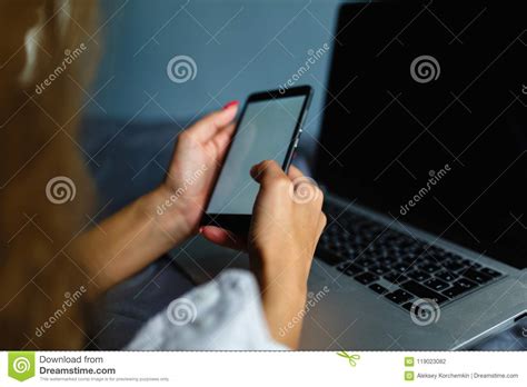 Lovely Blonde Woman Phoning With Her Smartphone Lying On Her Bed Next