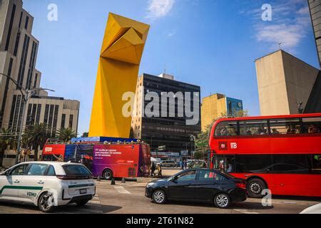 Metrobús passes by the yellow El Caballito statue by sculptor Enrique