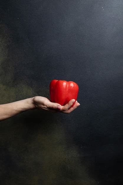 Mano Femenina Sostiene Verduras Sobre Un Fondo Oscuro Foto Premium