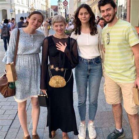 Four People Posing For A Photo On The Street