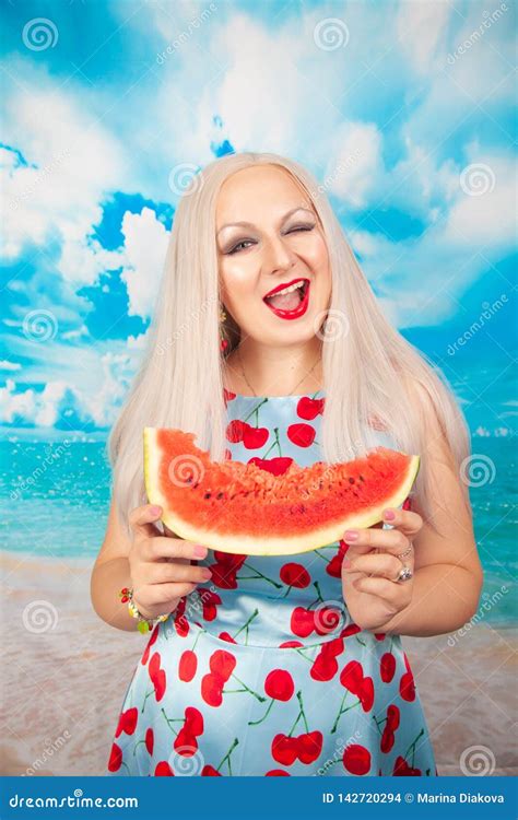 Charmerend Mollig Blonde In Blauwe Speld Kleed Omhoog Tribunes Met Een Stuk Van Watermeloen En