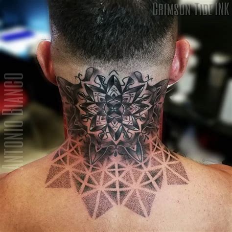 The Back Of A Man S Neck With An Intricate Tattoo Design On His Neck