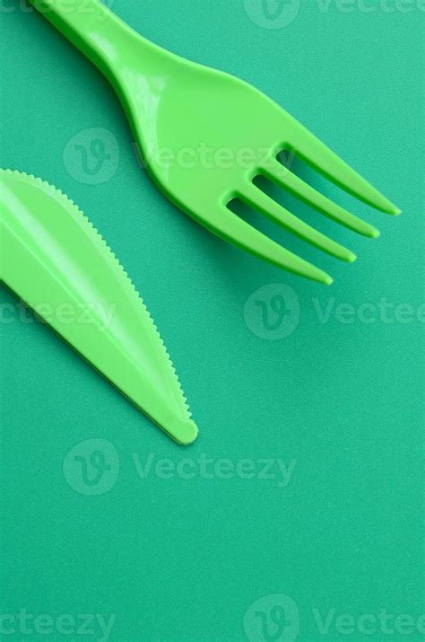 Disposable Plastic Cutlery Green Plastic Fork And Knife Lie On A Green
