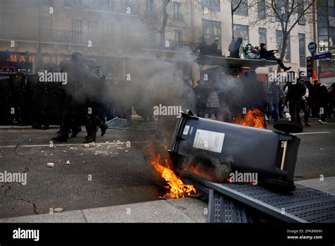 Les manifestants se tiennent à un arrêt de bus près des poubelles en