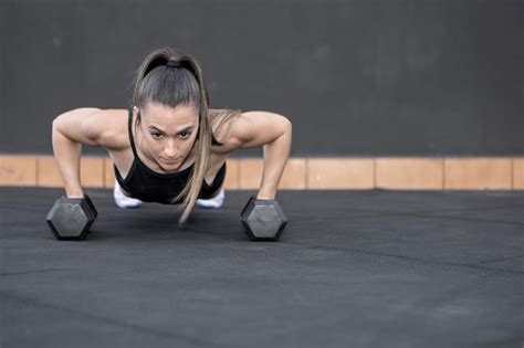 Premium Photo Sportswoman Doing Push Ups On Dumbbells