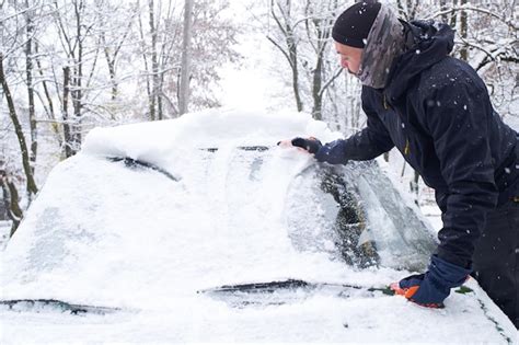 Premium Photo Man Cleans His Car After A Snowfall Cleaning Snow From