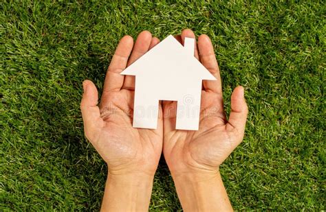 Hands Holding A House In Conceptual Image Of Plans For Housing