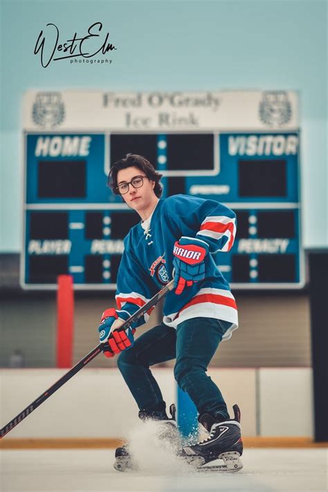 A Young Man Is Playing Hockey On The Ice