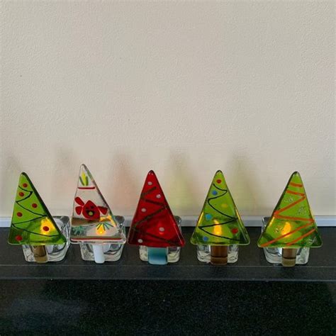 Small Glass Christmas Trees Lined Up On A Shelf