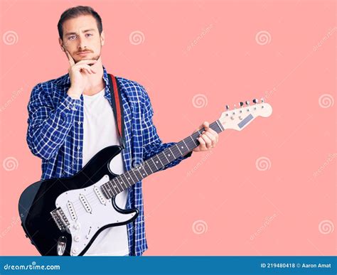 Young Handsome Caucasian Man Playing Electric Guitar Serious Face