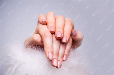 Diseño de uñas. manos con manicura de primavera rosa brillante en gris ...