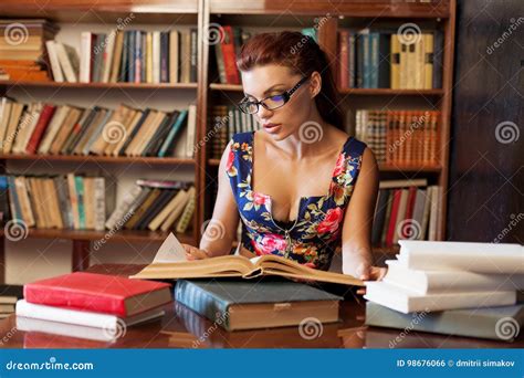 Woman Librarian in Glasses Sitting at the Table Studying Book Stock ...