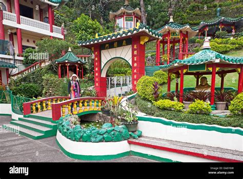 A tourist enjoys the Bell Church, a Taoist Temple, beautiful grounds ...