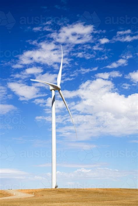 Image Of Single Wind Turbine Against Blue Sky With White Clouds