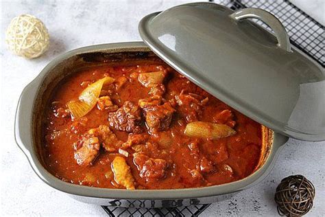 A Pot Filled With Stew Next To An Object On Top Of A Wire Rack