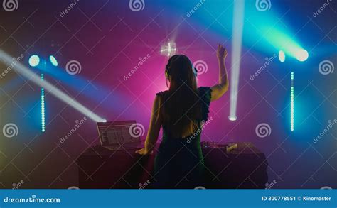 Female Dj Celebrating Music At Nightclub With Colorful Lights Stock