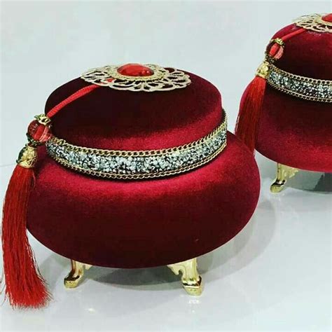 Two Red Velvet Covered Stools With Tassels And Chains On Them Sitting