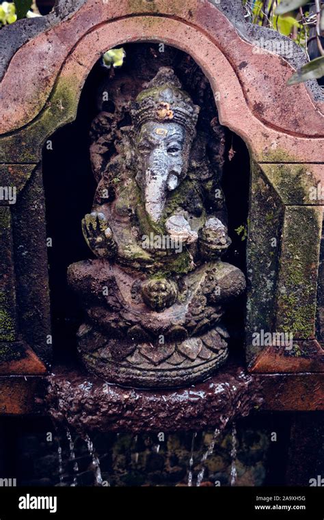 An Old Asian Statue Of Ganesha God Stands In The Garden Of A Temple