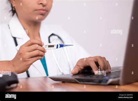 Doctor Explaining How To Use Fever Thermometer To Patient Through