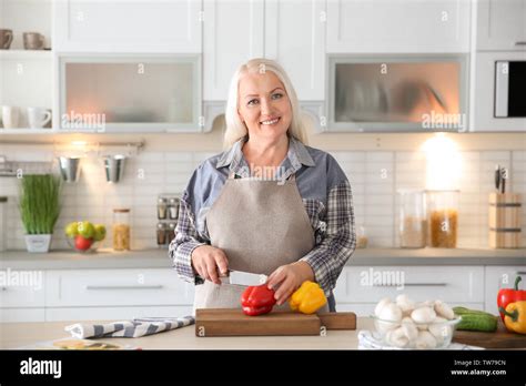 Beautiful Mature Woman Cooking In Kitchen Stock Photo Alamy