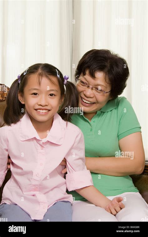 Mature Woman Sitting With Her Granddaughter And Smiling Stock Photo Alamy