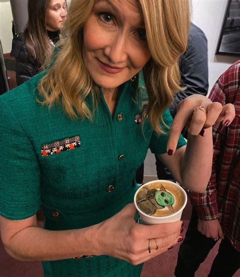 A Woman In A Green Dress Holding A Cup Of Coffee And Smiling At The Camera