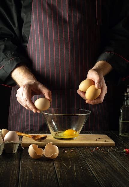 Premium Photo The Chef Prepares An Egg Omelette For Breakfast Working Environment In A