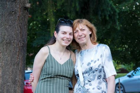 Beautiful Senior Mother And Her Adult Daughter Look At The Camera And