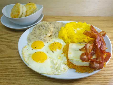 Bacon And Eggs Hash Browns Covered With Muenster Saffron Cheddar Cheese Grits Biscuits And