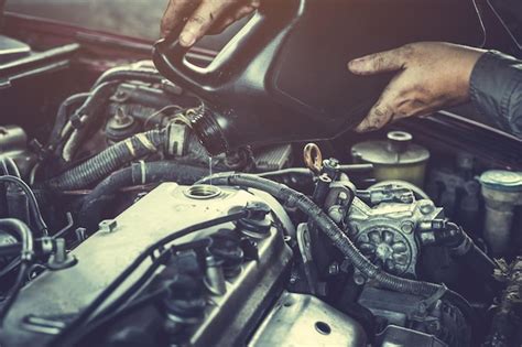 Premium Photo Cropped Image Of Mechanic Pouring Motor Oil In Car Engine