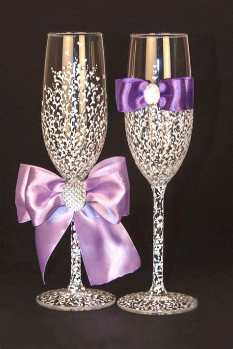 Two Wine Glasses With Purple Bows On Them Are Sitting Next To Each Other In Front Of A Black