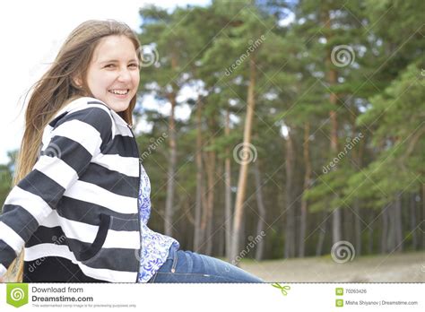 La Fille Blonde Avec De Longs Cheveux S Assied Et Sourit Photo Stock