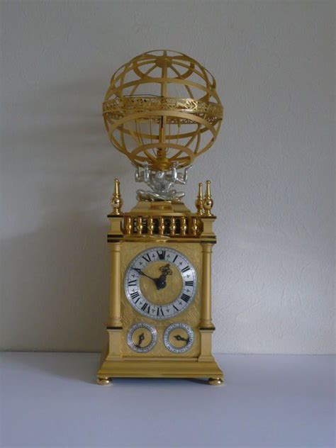 A Golden Clock With A Globe On Top