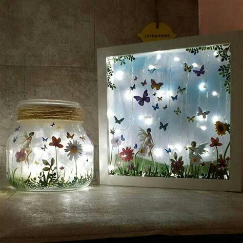 Two Glass Jars With Flowers And Butterflies In Them Sitting On A