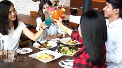 Four Asian Good Friends Toasting Saying Cheers And Holding Tropical