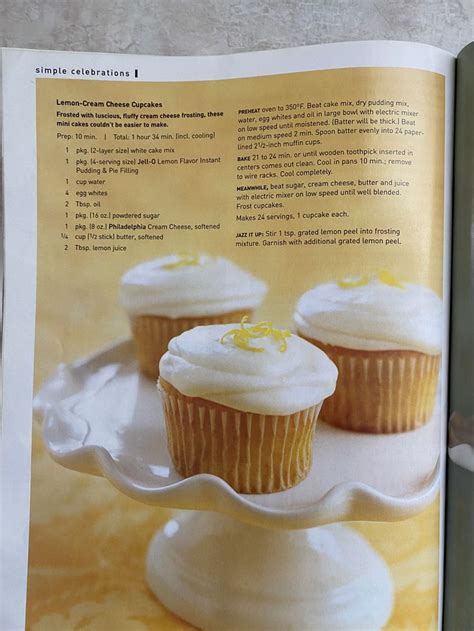 The Recipe Book Is Open To Show Cupcakes On A Cake Plate With Frosting