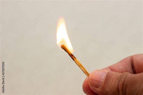 Lit match in hand. A lit match on a white background. Lighted match in ...