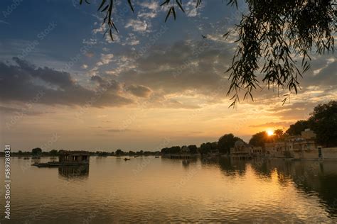 Beautiful sunset at Gadisar lake, Jaisalmer, Rajasthan, India. Setting sun and colorful clouds ...