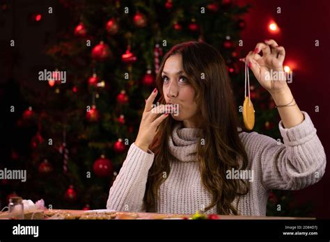 Pretty Brunette Girl Licks Her Fingers Decorating Christmas Cookies Stock Photo Alamy