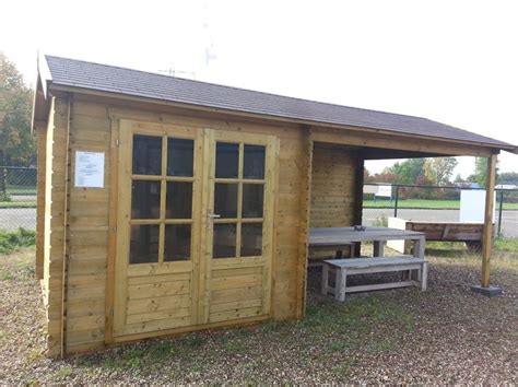 A Small Wooden Shed With Two Picnic Tables