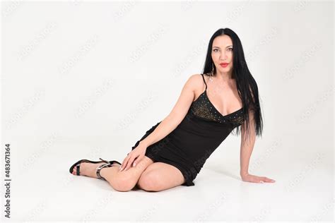 Beautiful Woman Aged Brunette Sitting On The Floor In The Studio On A White Background Stock