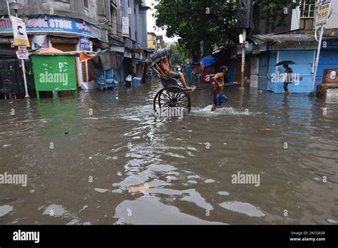 A Rickshaw Puller Waded Through A Water Logged Street Carrying A