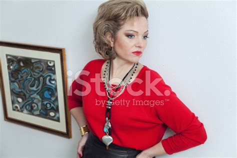 Beautiful Blonde Woman Posing Against Wall With Pictures Stock Photo Royalty Free Images