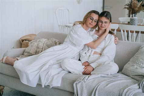 Premium Photo Blonde Italian Woman In White Clothes Sitting With Daughter On Couch Home