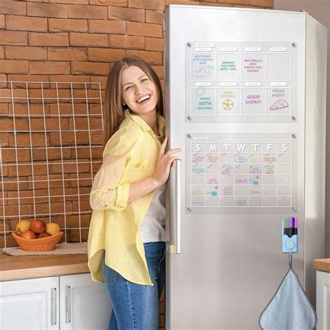 A Woman Standing Next To A Refrigerator In A Kitchen