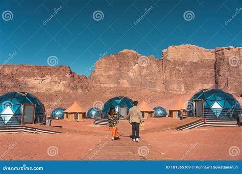 Young Couple In Love Standing On Wooden Way In Martian Dome Tents In
