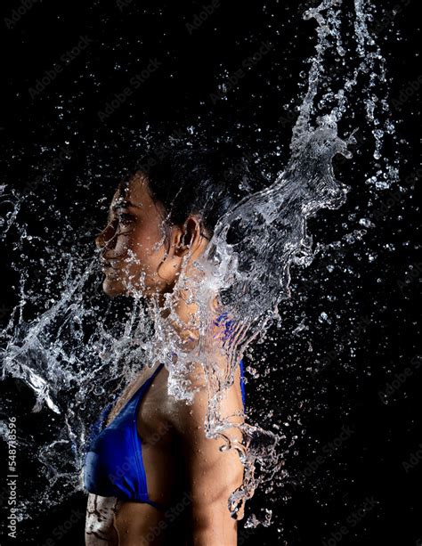 Tanned Skin Asian Woman In Bikini Poses In Aqua Studio Splash Drops Of Water Spread To Body