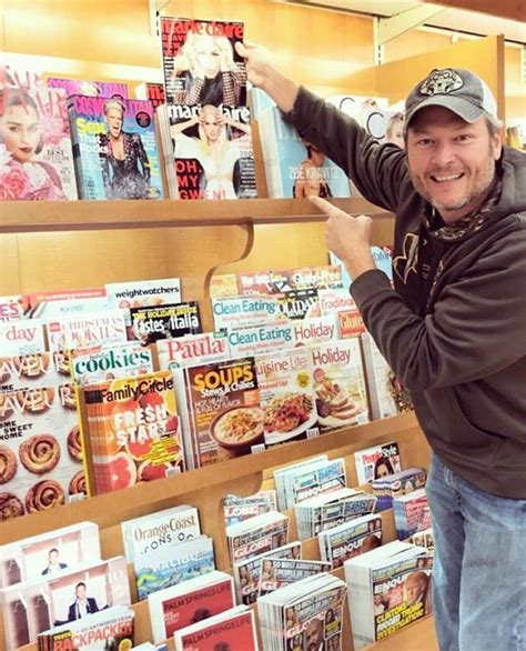 A Man Standing In Front Of A Display Of Magazine S And Doughnuts