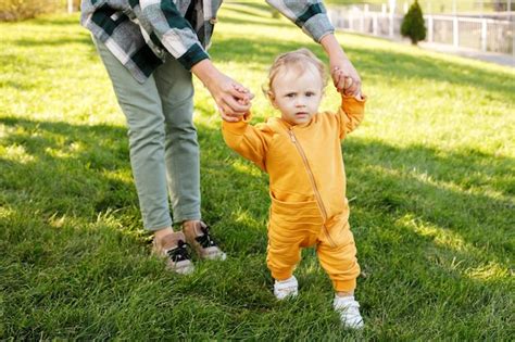 Premium Photo Baby With Mom Makes First Steps In The Park